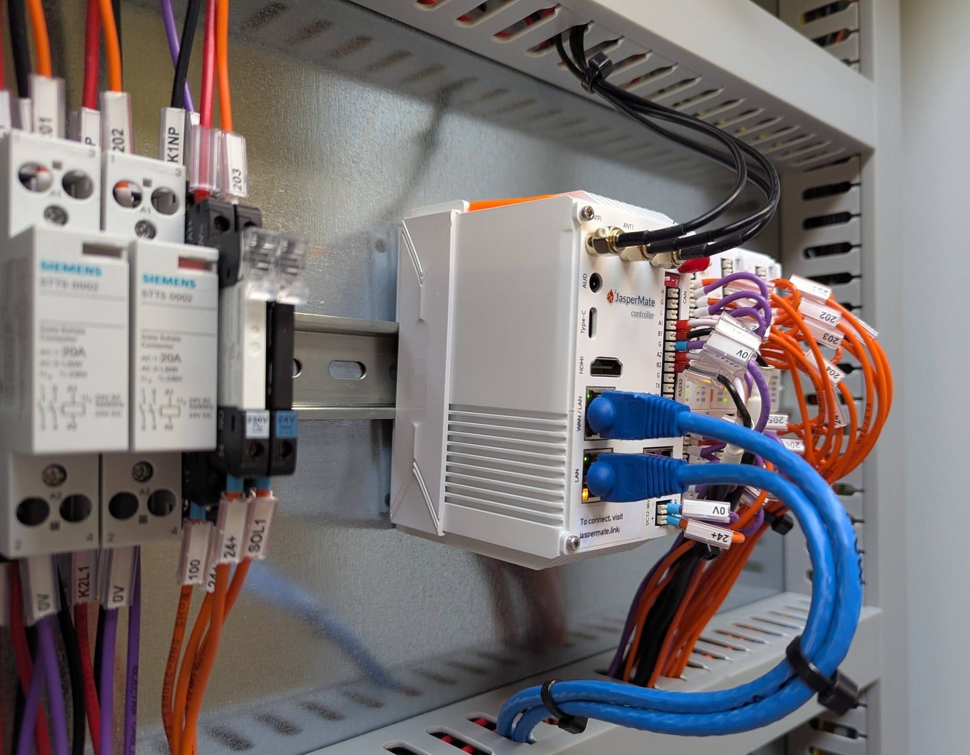 A JasperMate controller on the DIN rail in a control panel, wired to contactors, relays and Ethernet